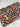 Colorful Halloween-themed fabric with various phrases on a white wooden surface