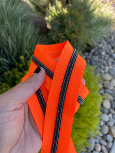 Neon orange zipper tape with black teeth
