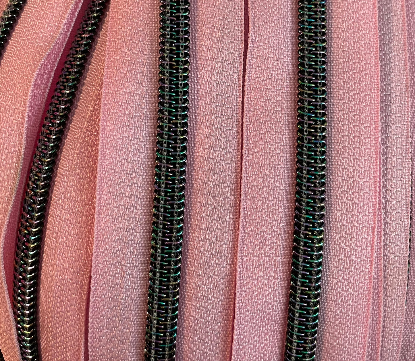 Pink zipper tape with black iridescent teeth